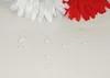 Close-up of water droplets on a white surface with white and red flowers in the background. Náhled obrázku produktu