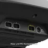 Close-up view of the back ports of a gaming accessory, showing expansion ports, an Xbox/PC connection, and a power input. Podgląd zdjęcia produktu