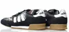 A pair of black Adidas sneakers with white stripes and tan soles, shown from the side against a white background. Anteprima dell’immagine prodotto
