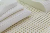 Several white latex pillows stacked on a perforated latex mattress topper. Náhľad obrázku produktu