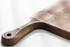 A close-up shot of a wooden cutting board with a decorative handle. Anteprima dell’immagine prodotto