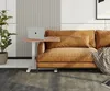 A mobile side table with a laptop and a phone on it, placed next to a brown couch. Produktbild-Vorschau