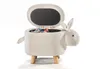 A white, sheep-shaped storage ottoman with its lid open, revealing some colorful items inside. It has four wooden legs and is photographed against a white background. Produktbild-Vorschau