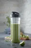A green smoothie in a clear bottle with a black lid, placed on a kitchen counter with kiwi slices and lime wedges nearby. Náhľad obrázku produktu