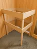 A wooden frame structure, likely a sauna, is shown in a corner with wooden walls and a grey floor. Produktbild-Vorschau