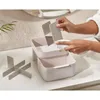 A person's hands are shown cleaning a cosmetic organizer on a countertop. Náhled obrázku produktu