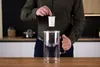 A person is shown inserting a filter cartridge into a glass pitcher. Produktbild-Vorschau