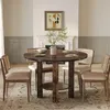 A round wooden dining table with four chairs in a dining room setting. Voir les images du produit