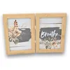 A double photo frame made of wood, with two pictures inside, one with flowers and the other with the word "Breathe" and flowers. Produktbild-Vorschau