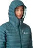A woman wearing a teal puffer jacket. Anteprima dell’immagine prodotto