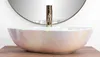 A close-up shot of a vessel sink with a faucet, placed on a wooden surface, with a mirror in the background. Náhľad obrázku produktu