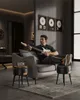 A man playing a guitar while sitting on a sofa in a modern living room. Náhled obrázku produktu