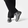 A person wearing black pants and silver high-top sneakers. Anteprima dell’immagine prodotto