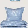 A folded duvet and a pillow with a snowflake print on a light gray background. Produktbild-Vorschau