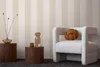 A stylish interior scene featuring a chair, side tables, and decorative items against a striped wallpaper. Produktbild-Vorschau