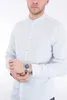 A man wearing a light blue collared shirt and a silver watch on his left wrist. Produktbild-Vorschau