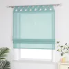 A teal Roman shade with a decorative top border hangs in a window. Produktbild-Vorschau