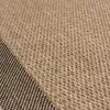 A close-up view of a woven rug with a diagonal split between a beige section and a black section. Náhľad obrázku produktu