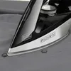 Close-up of a Black+Decker iron pressing a grey shirt near buttons. Produktbild-Vorschau