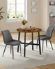 A dining set with a round table and two chairs in a room with a window. Produktbild-Vorschau