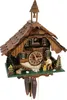 A detailed, front-facing view of a traditional wooden cuckoo clock, designed to resemble a small house with intricate carvings and miniature figures. Anteprima dell’immagine prodotto