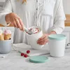 A person is scooping ice cream from a container into an ice cream cone. Produktbild-Vorschau