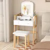 A white vanity table with a lighted mirror and a white stool in a bedroom setting. Produktbild-Vorschau
