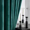 A close-up view of green velvet curtains next to decorative candles and candle holders on a table. Produktbild-Vorschau