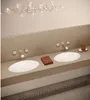 A modern bathroom vanity with two sinks, faucets, and a towel. Produktbild-Vorschau