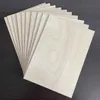 A stack of thin wooden sheets fanned out on a dark surface. Produktbild-Vorschau