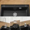 A collage of images showing a black granite kitchen sink with various accessories, including a faucet, soap dispenser, and a glass rinser. Produktbild-Vorschau