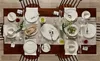 A dining table set for a meal with plates, cutlery, and food. Náhľad obrázku produktu