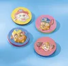 Four circular craft items with embossed dog faces from Paw Patrol, arranged on a blue background. Produktbild-Vorschau