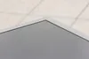 A close-up view of the corner of a screen or monitor, with a light-colored tiled surface in the background. Produktbild-Vorschau