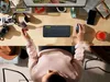 A person's hands are shown using a Logitech ERGO M575 Trackball mouse and keyboard on a wooden desk. Anteprima dell’immagine prodotto