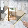 A hand holding a squeegee cleaning a window with water droplets. Náhľad obrázku produktu