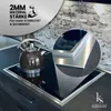 A close-up of a modern kitchen countertop featuring a black induction cooktop with a silver frame. A dark gray kettle is placed on the cooktop. A circular inset zooms in on the edge of the cooktop frame, highlighting its material and thickness. The backgro Anteprima dell’immagine prodotto
