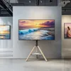 A TV stand with a TV displaying a beach scene, set up in what appears to be an art gallery or showroom. Produktbild-Vorschau