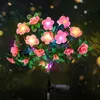 Rosa solarbetriebene Blumenleuchten mit grünen Blättern, die in einem dunklen Garten leuchten Anteprima dell’immagine prodotto
