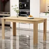 A wooden dining table is shown in a kitchen setting. There are cabinets and a coffee machine in the background, and the floor is reflective. Náhled obrázku produktu