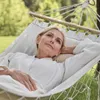 A woman relaxes in a hammock outdoors. Produktbild-Vorschau