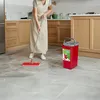 A person is mopping a kitchen floor with a red mop and bucket. Produktbild-Vorschau