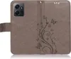 A brown flip case for a smartphone, featuring a floral and butterfly embossed design. Produktbild-Vorschau