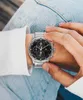 A person wearing a watch and jeans. Produktbild-Vorschau
