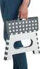 A person's hands are holding a folded gray and white step stool. Podgląd zdjęcia produktu