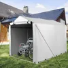 A silver-gray storage tent is set up on a green lawn in front of a house. Inside the tent, a hose reel cart and a bicycle wheel are visible. Podgląd zdjęcia produktu