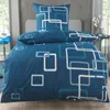 A neatly made bed with blue bedding featuring a geometric pattern. Produktbild-Vorschau