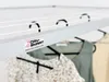 A close-up view of a ceiling-mounted clothes drying rack with clothes hanging on it. Voir les images du produit
