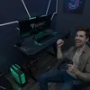 A man is happily playing a video game at a gaming desk. Produktbild-Vorschau