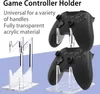 A product image showcasing two clear acrylic game controller stands, each holding a black game controller. Text overlays describe the product's features. Produktbild-Vorschau